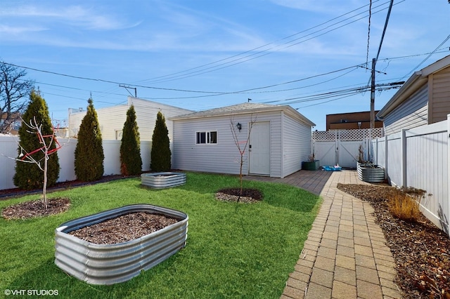 view of yard with an outbuilding, a vegetable garden, and a fenced backyard