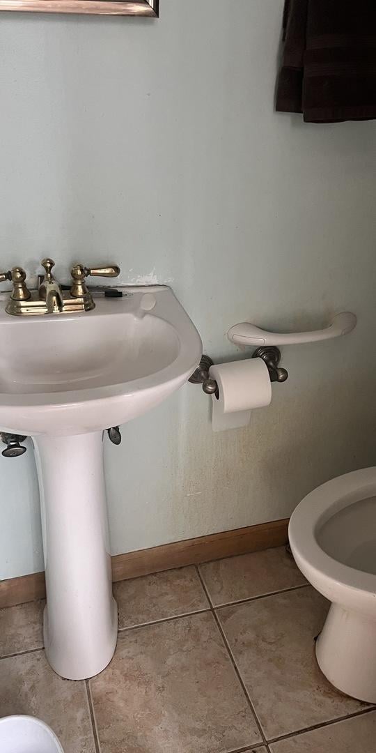 bathroom featuring baseboards, toilet, and tile patterned floors