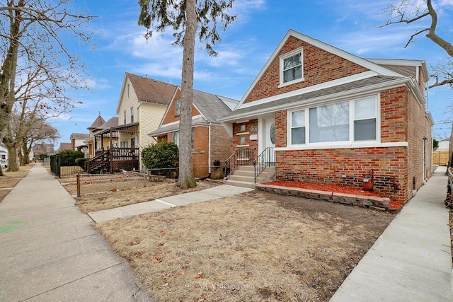 bungalow with a residential view, brick siding, and fence