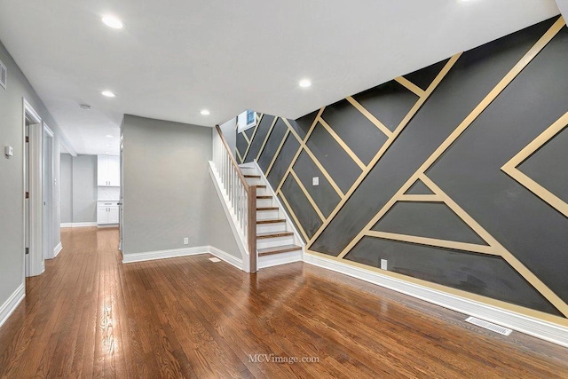 interior space featuring recessed lighting, wood finished floors, visible vents, baseboards, and stairway