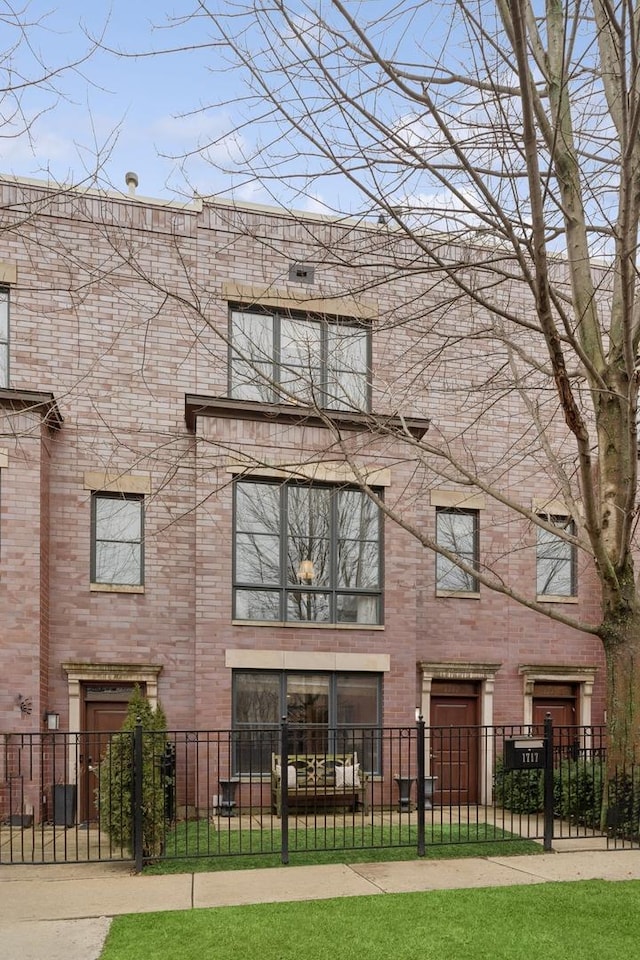 view of front of house with a fenced front yard and brick siding