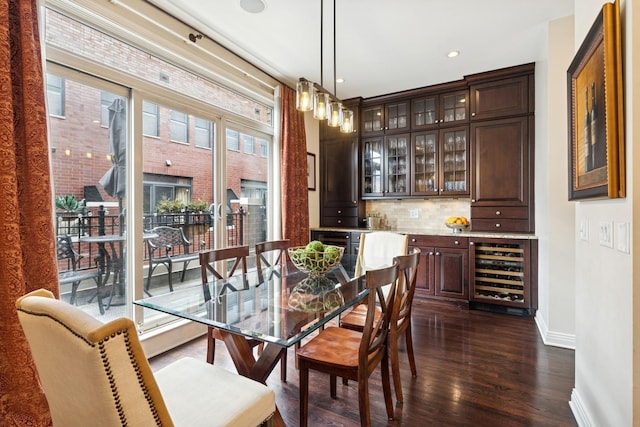 dining space featuring baseboards, recessed lighting, dark wood-type flooring, bar, and wine cooler