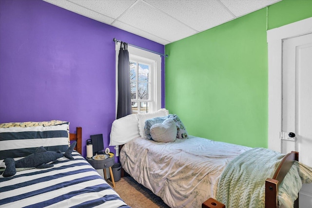 bedroom featuring carpet floors and a paneled ceiling