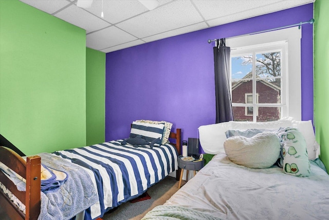 bedroom featuring a drop ceiling and carpet flooring