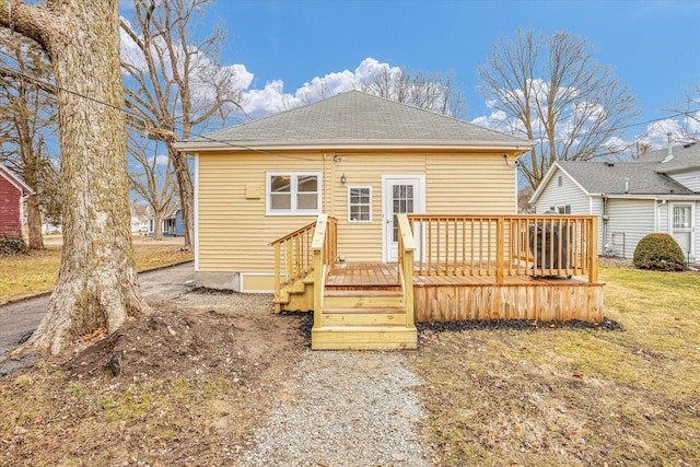 back of property featuring a shingled roof and a wooden deck