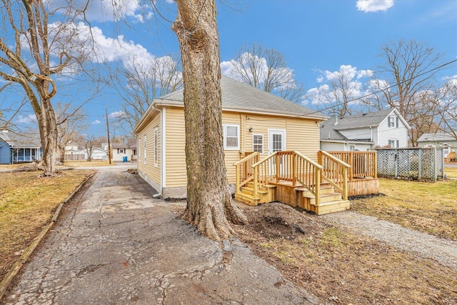 exterior space featuring driveway and roof with shingles