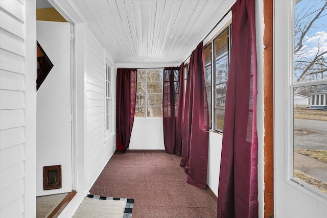 corridor with carpet floors and wooden ceiling