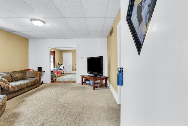 carpeted living room featuring a paneled ceiling, visible vents, and baseboards