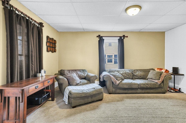 living room featuring carpet flooring and a drop ceiling