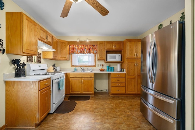 kitchen with light countertops, a sink, ceiling fan, white appliances, and under cabinet range hood