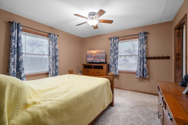 bedroom with a ceiling fan, light colored carpet, and baseboards