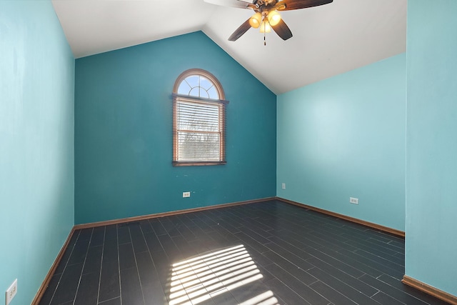 spare room with dark wood-style floors, baseboards, ceiling fan, and vaulted ceiling