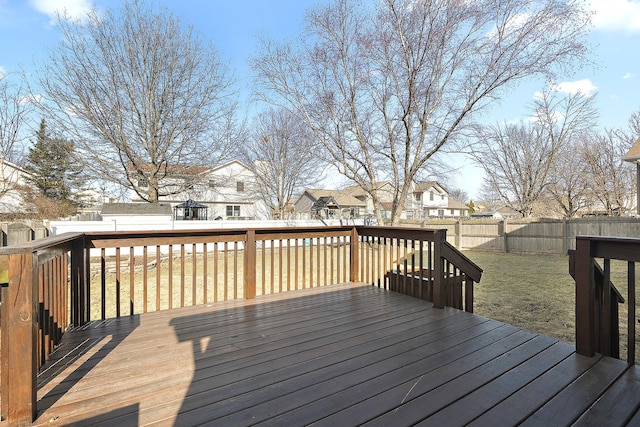 wooden deck featuring a yard, a residential view, and a fenced backyard