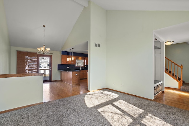 interior space featuring a chandelier, visible vents, carpet flooring, and brown cabinetry