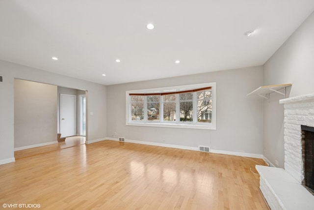 unfurnished living room featuring light wood-style floors, a fireplace, visible vents, and recessed lighting