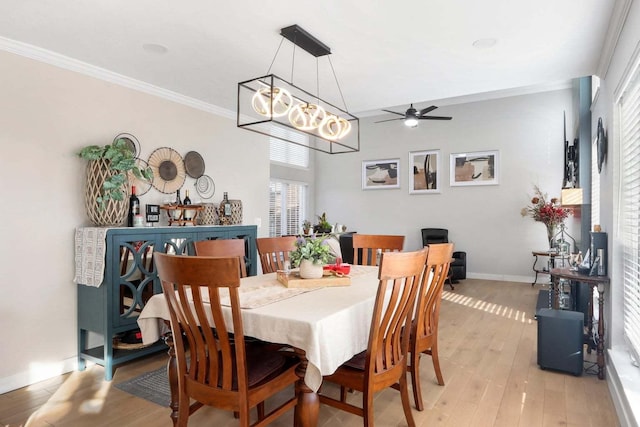 dining room with light wood-type flooring, a ceiling fan, baseboards, and crown molding