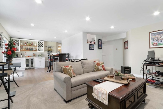 living room with beverage cooler, a bar, light wood-style flooring, and recessed lighting