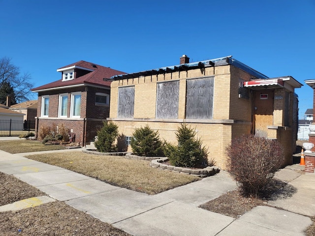 view of front facade with brick siding and fence