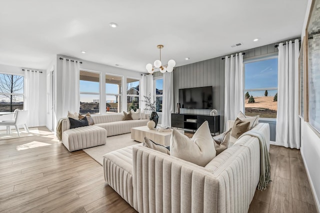 living area with recessed lighting, a notable chandelier, and wood finished floors