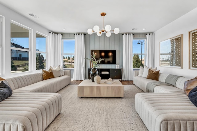 living room with recessed lighting, plenty of natural light, visible vents, and a notable chandelier