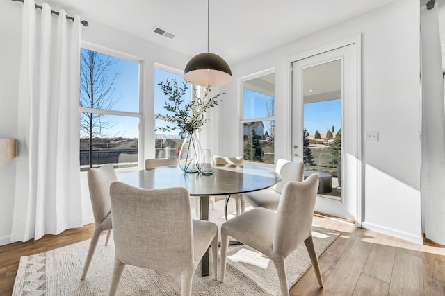 dining room with light wood finished floors and visible vents