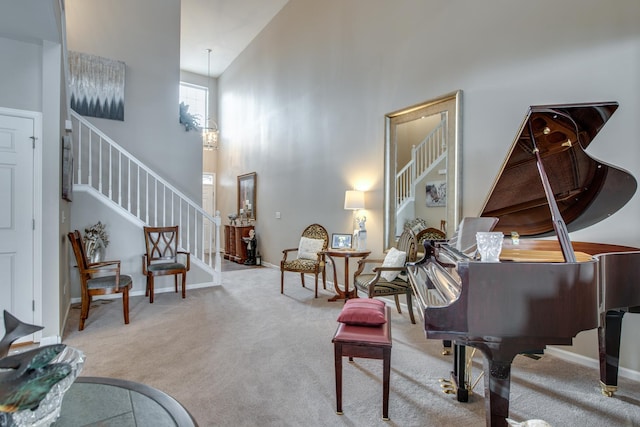 living area featuring baseboards, a high ceiling, stairway, and carpet flooring