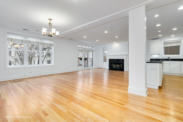 unfurnished living room featuring recessed lighting, a fireplace, and light wood-style flooring