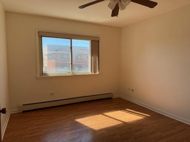 empty room featuring a baseboard radiator, baseboards, ceiling fan, and wood finished floors