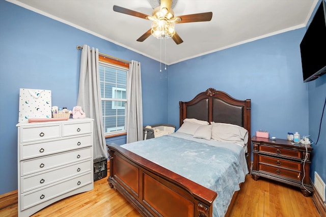 bedroom featuring ornamental molding, ceiling fan, and light wood-style flooring