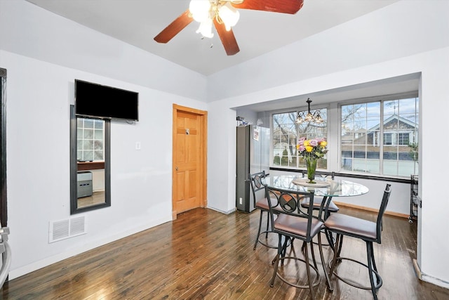 dining room with dark wood-style floors, visible vents, baseboards, and ceiling fan with notable chandelier