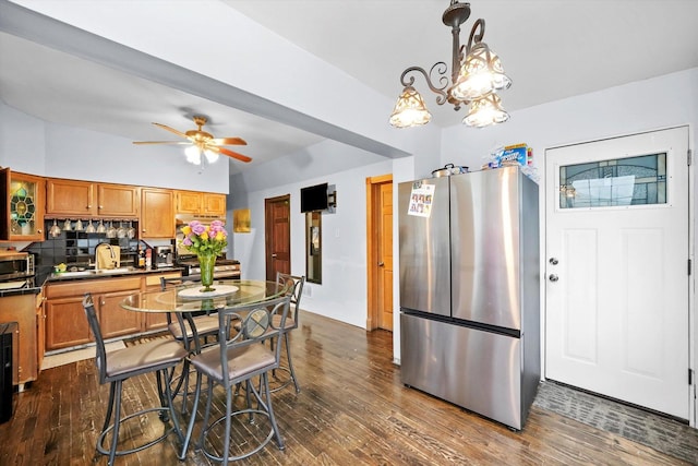 kitchen with appliances with stainless steel finishes, backsplash, dark countertops, and dark wood finished floors