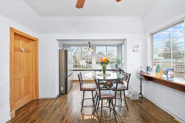 dining area with a healthy amount of sunlight, dark wood finished floors, baseboards, and ceiling fan with notable chandelier