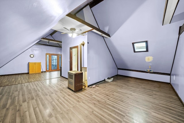 additional living space with baseboards, ceiling fan, light wood-style flooring, heating unit, and vaulted ceiling