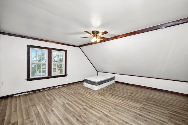 additional living space with lofted ceiling, ceiling fan, wood finished floors, and baseboards