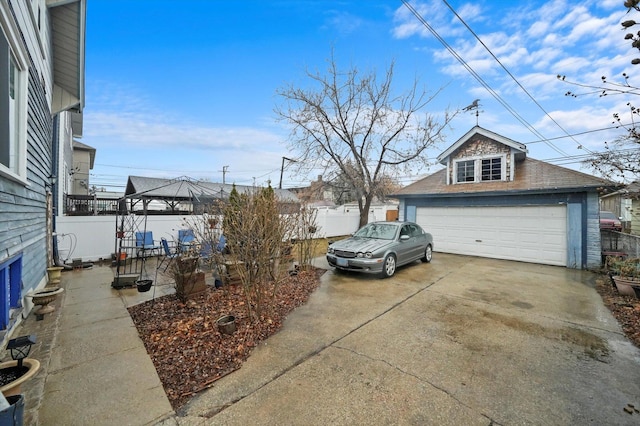 view of yard with a garage, fence, and an outbuilding