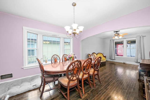 dining room with arched walkways, dark wood finished floors, baseboards, and ceiling fan with notable chandelier