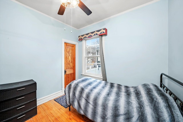 bedroom with baseboards, crown molding, light wood finished floors, and ceiling fan