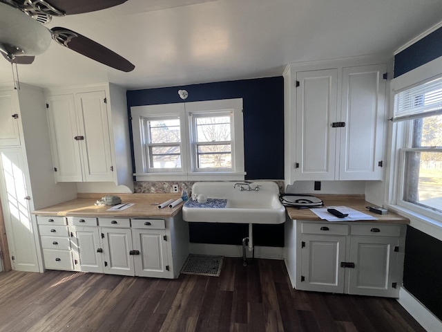 kitchen featuring dark wood-style floors, light countertops, a sink, and white cabinetry