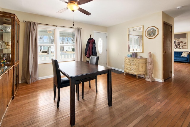 dining room with hardwood / wood-style floors, baseboards, and ceiling fan