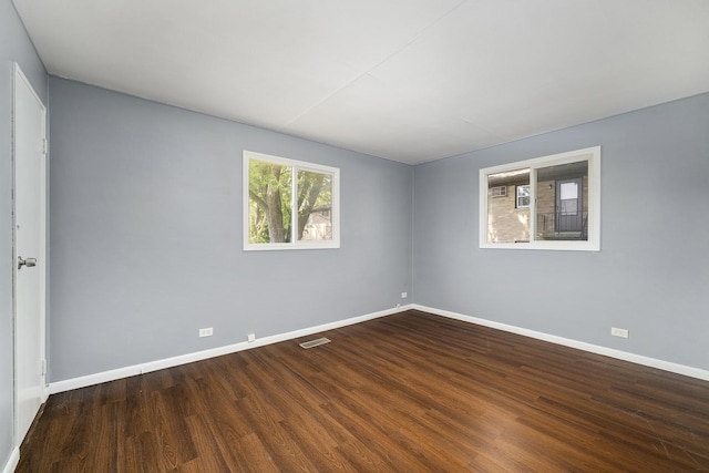 unfurnished room featuring visible vents, baseboards, and wood finished floors