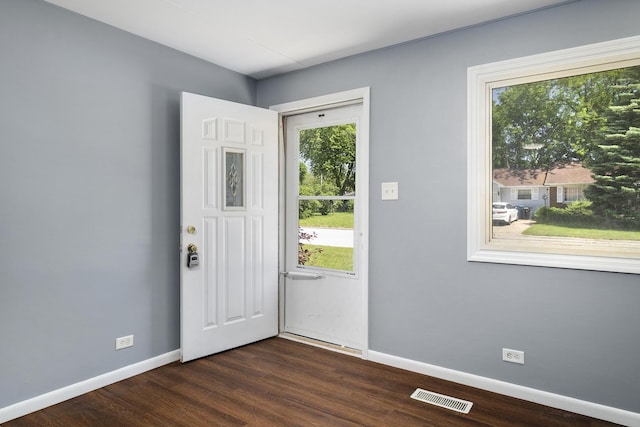 entrance foyer with baseboards, visible vents, and dark wood-type flooring