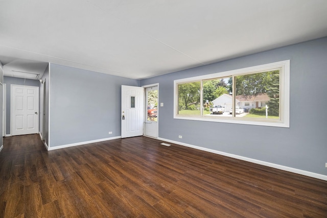 spare room with visible vents, wood finished floors, attic access, and baseboards