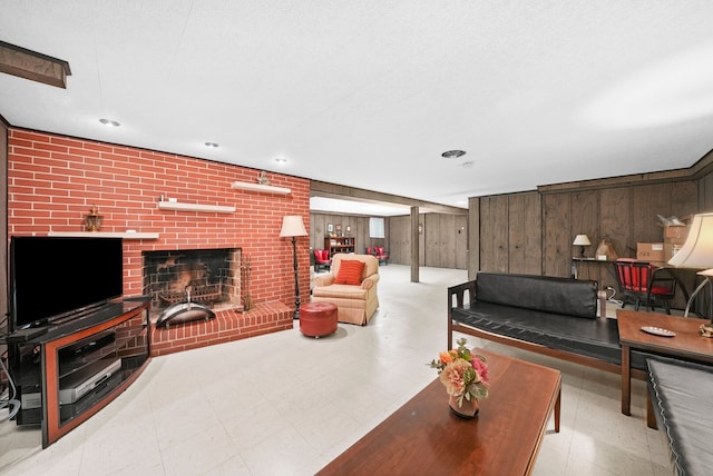 living room with tile patterned floors, wooden walls, and a brick fireplace