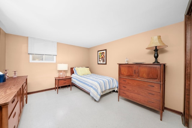 bedroom with light floors and baseboards