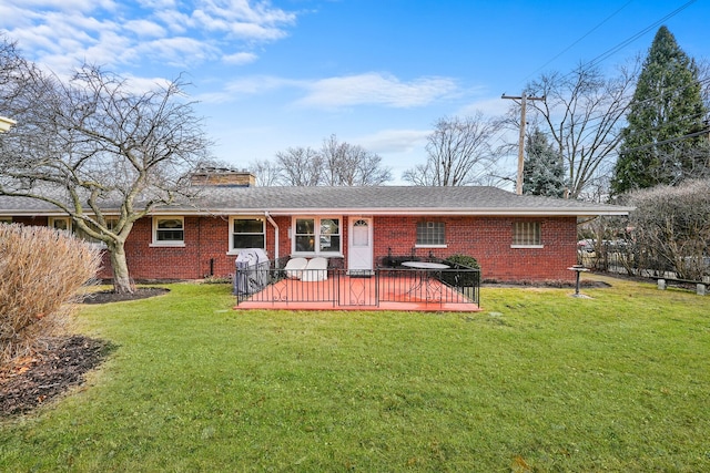 back of house with fence, brick siding, a chimney, and a lawn