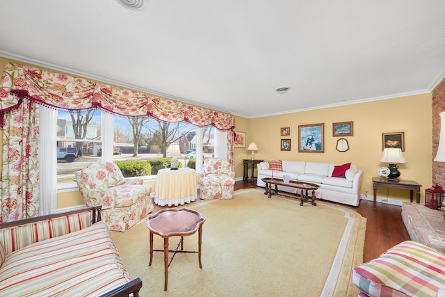 living area with crown molding, wood finished floors, visible vents, and baseboards