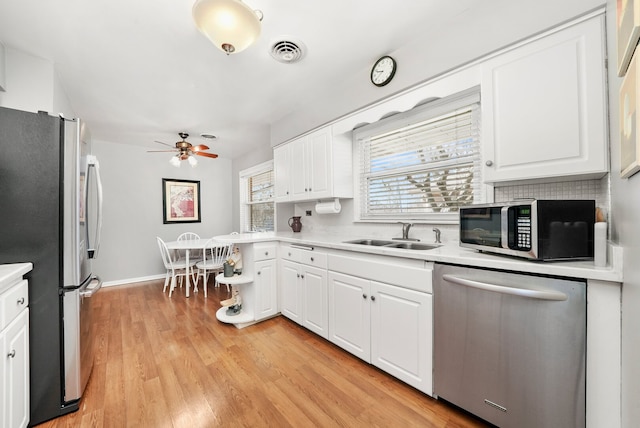 kitchen featuring a sink, visible vents, appliances with stainless steel finishes, and white cabinets