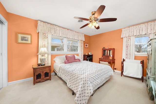 bedroom featuring multiple windows, baseboards, visible vents, and light carpet