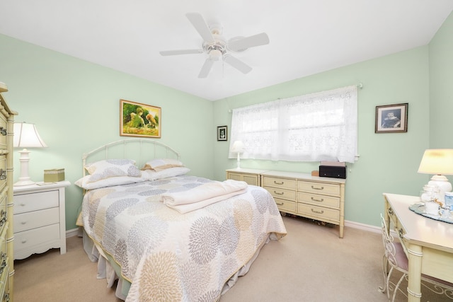 bedroom featuring baseboards, light colored carpet, and a ceiling fan