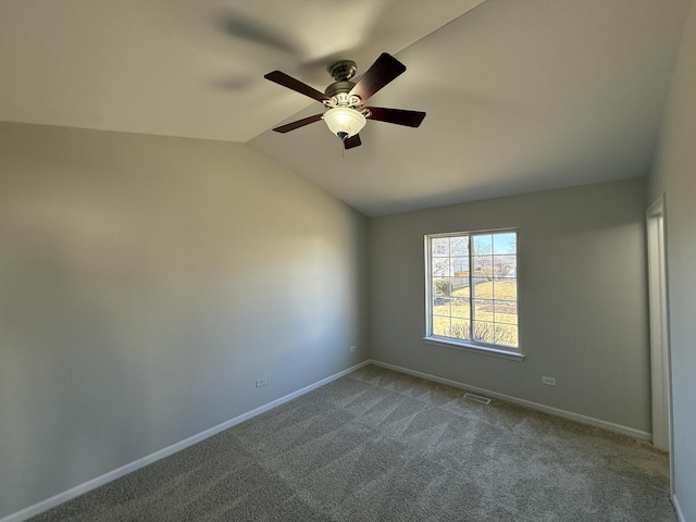 empty room featuring lofted ceiling, dark carpet, a ceiling fan, and baseboards